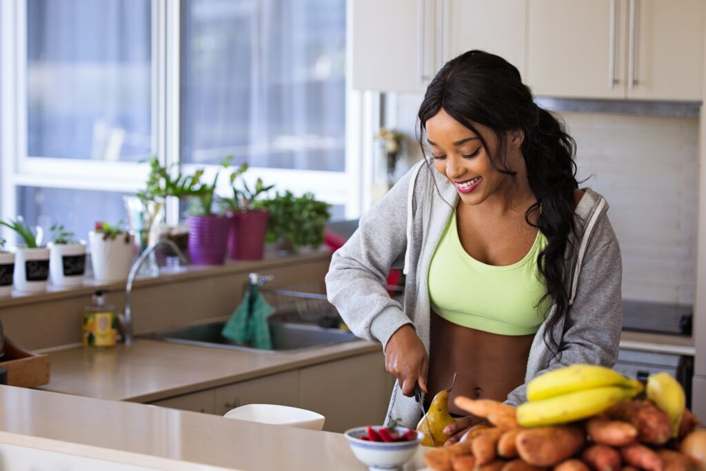 Woman preparing a healthy meal in the kitchen during her ovulation phase.